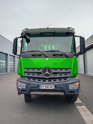 un camion vert garé sur un parking