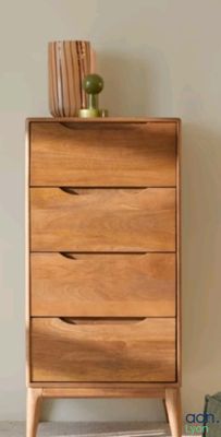 a wooden chest of drawers with a plant on top of it