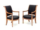 pair of black upholstered chairs with wooden arms and arms