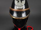 an old helmet with a red cord attached to it on a black surface