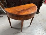une petite table en bois au plateau incurvé, posée à même le sol