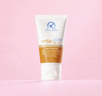un tube de crème solaire sur fond rose