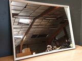 a large mirror sitting on top of a wooden table