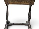 an old wooden table with a carved top and legs