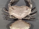 an image of a silver crab with a heart on it ' s back