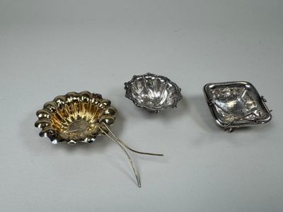 trois broches en argent et en or sur un fond blanc