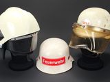 deux casques blancs et un casque blanc exposés sur une surface noire