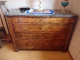 une commode en bois avec un plateau en marbre sur lequel est posée une lampe