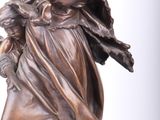 bronze statue of a woman holding a child on a rock