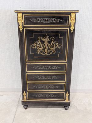 une commode noire et dorée ornée de motifs élaborés