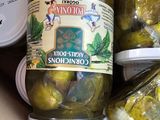 several jars of pickles are in a cardboard box on a table
