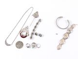 a lot of silver jewelry on a white surface
