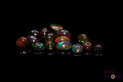 plusieurs perles de verre de différentes couleurs posées sur une surface noire