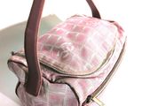 a pink and white plaid purse sitting on a white plate