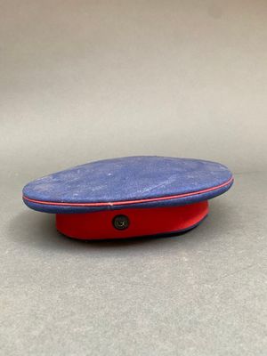 un chapeau bleu et rouge avec un bouton sur le dessus