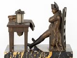 statue of a man sitting at a desk with a lamp on it