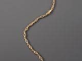 an image of a gold necklace on a gray background