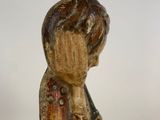wooden figurine of a boy holding a bird on a white background