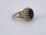 a close up of a gold ring with a blue stone