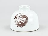 a white vase with a brown design on it