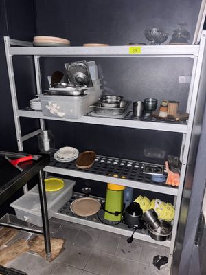 une étagère avec des casseroles et des poêles dans une cuisine