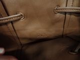 a person holding a brown purse with two handles
