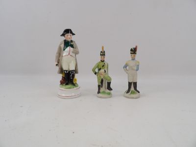 three figurines of men dressed in military uniforms