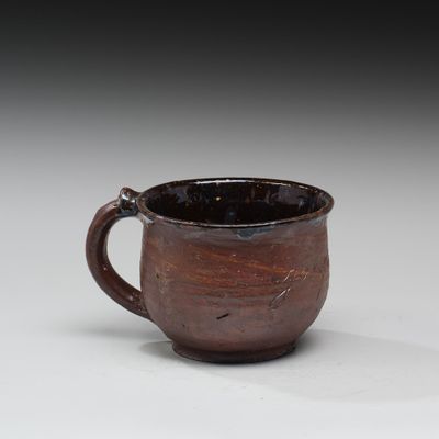 une tasse marron posée sur une table
