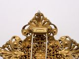 an ornate gold broochle with a clock in the middle of it
