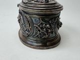 a metal container with a lid on a white surface