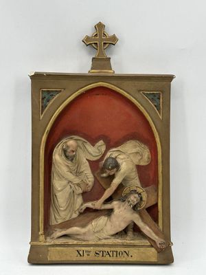 statue of jesus nailed to the cross in a frame with a cross above it