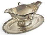 an antique silver plate with a saucer and a saucer on it