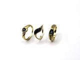 two gold rings with black stones on them on a white surface