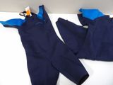 two pairs of wetsuits are laying on a white surface