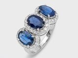 a close up of a three stone ring with blue sapphires and diamonds