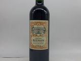 la bouteille de vin rouge est posée sur une surface blanche