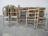 three metal chairs and a wooden pallet in a room