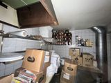 une cuisine où il y a plein de cartons, les uns sur les autres, sur le plan de travail