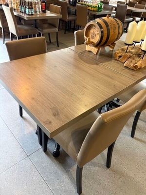 tables and chairs in a restaurant with wine barrels on top of them