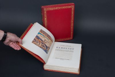 someone is holding a book with a red cover and a black background