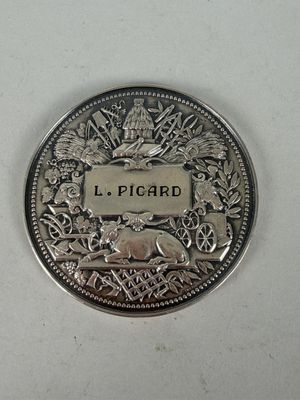 a silver coin with a picture of a bear on it