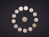 un gros plan sur un cercle de pièces de monnaie posé sur une surface noire