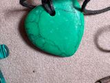 a green heart shaped stone with a cross on it