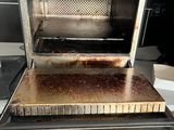 a toaster oven that has been burnt and is sitting on top of a counter