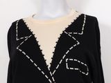an image of a black sweater with white stitching on it