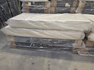 a pile of mattresses sitting on a pallet in a warehouse