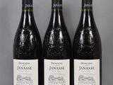 trois bouteilles de vin rouge posées sur une table l'une à côté de l'autre