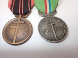 two medals with a cross and a medal on a white surface