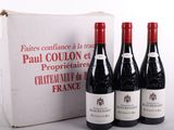 trois bouteilles de vin rouge sont posées devant une boîte blanche
