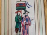 framed picture of a couple of people holding an umbrella in a room